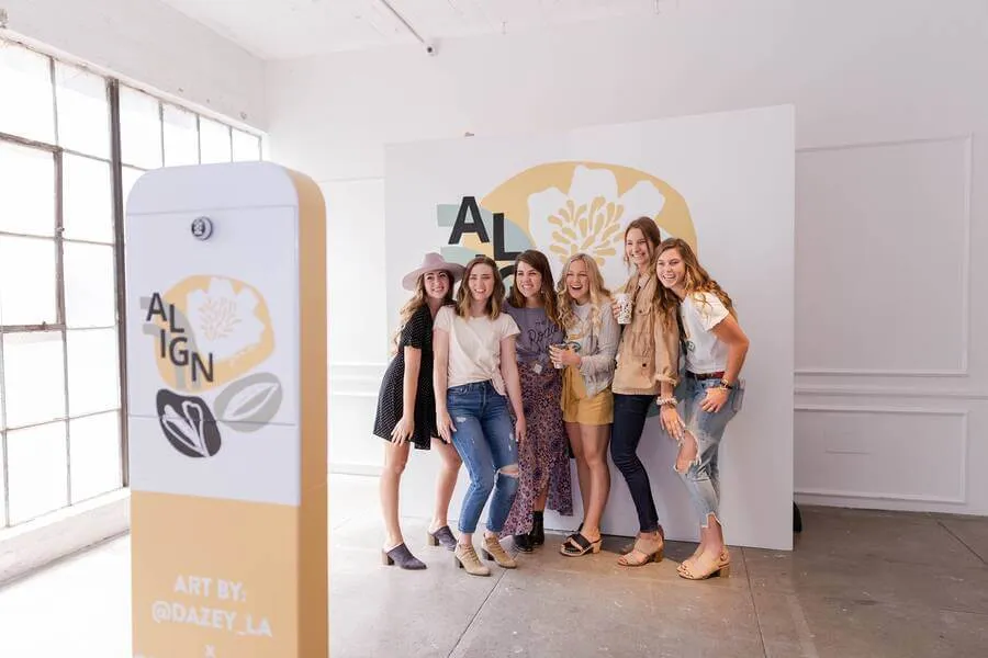 women posing for photo in front of selfie stand