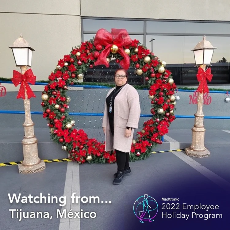 Employee by a giant wreath in a "Watching from Tijuana, Mexico" frame