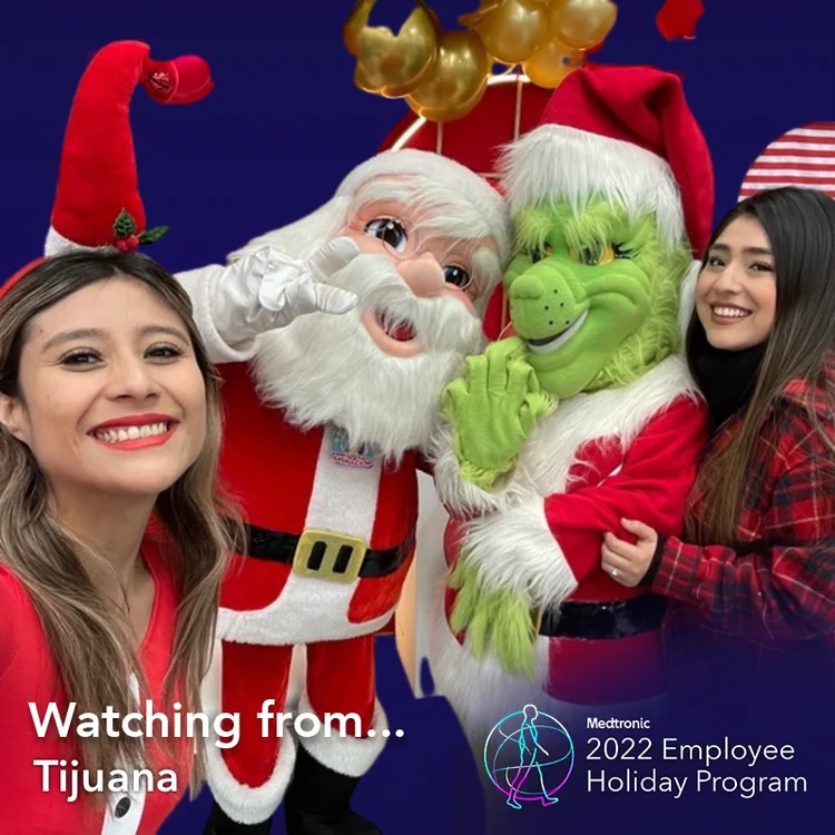 Employees posing with Santa and the Grinch in a "Watching from Tijuana" holiday frame
