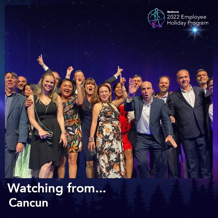 Group of employees cheering in a "Watching from Cancun" frame