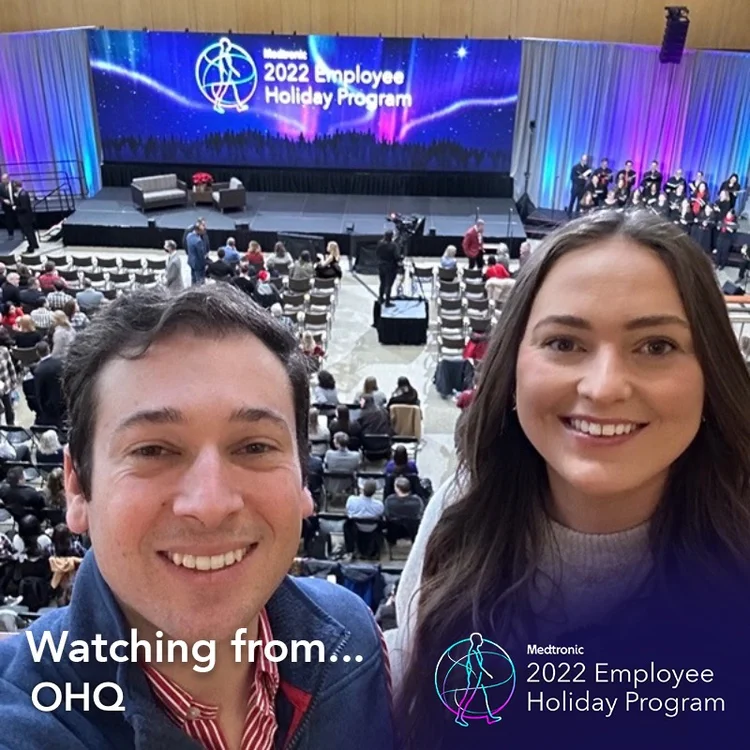 Two employees taking a selfie in a "Watching from OHQ" holiday frame