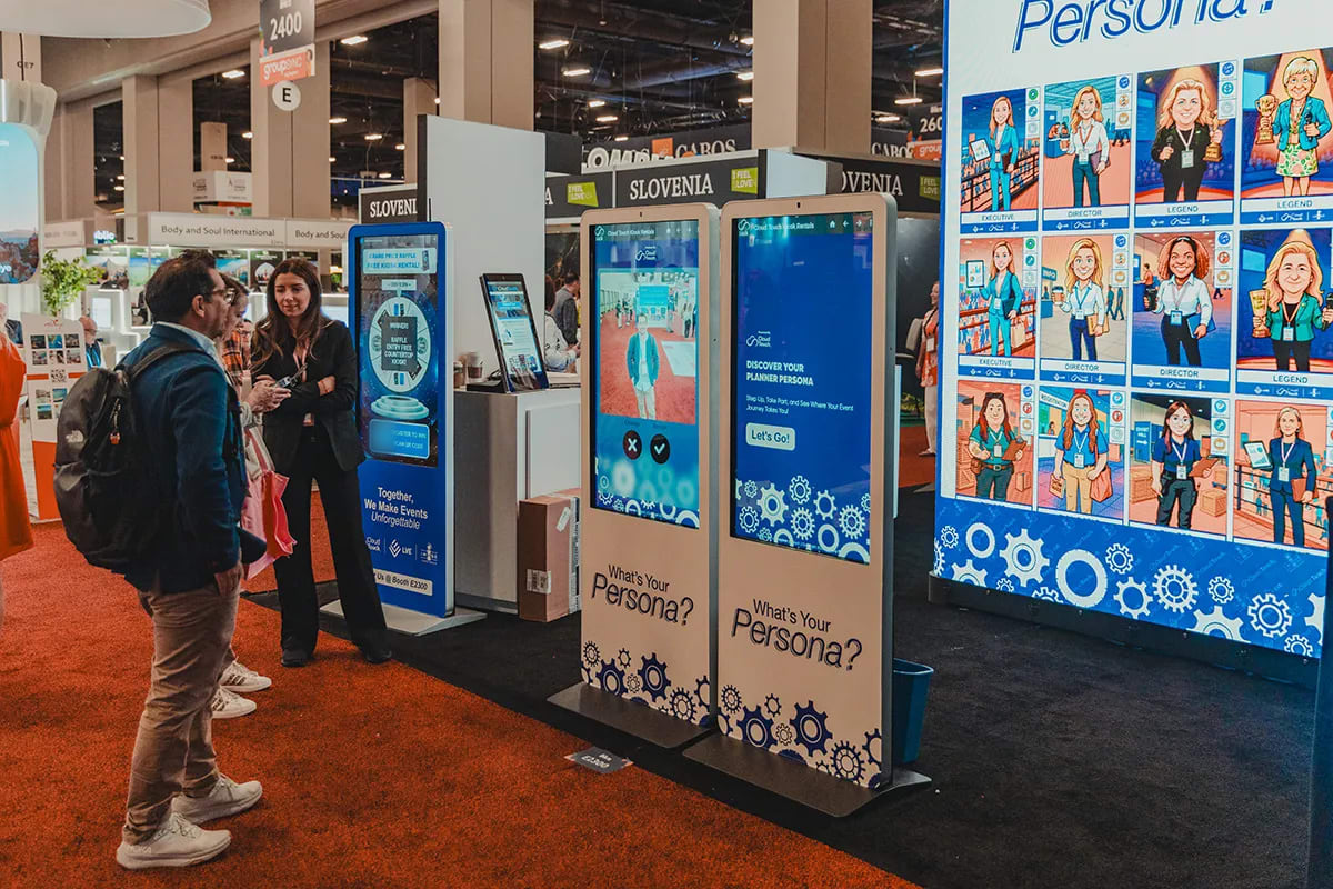 Attendees at a trade show stand in front of two touchscreen kiosks running a persona quiz, next to a wall of illustrated quiz results